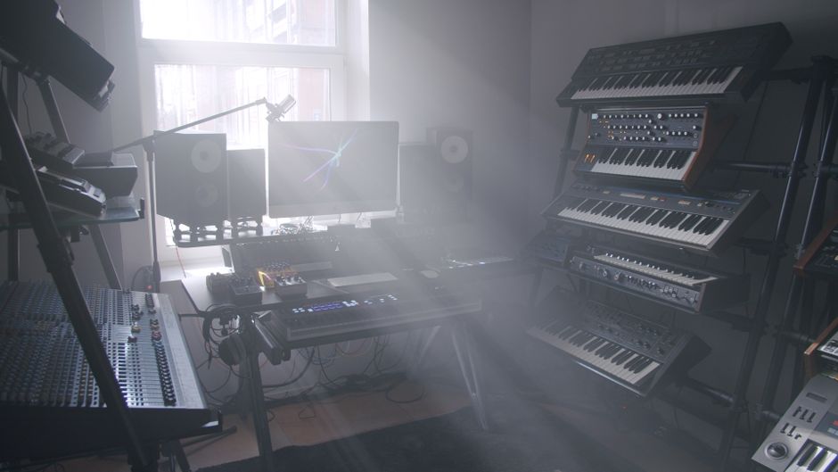 Bright recording studio filled with musical equipment and soft morning light rays.